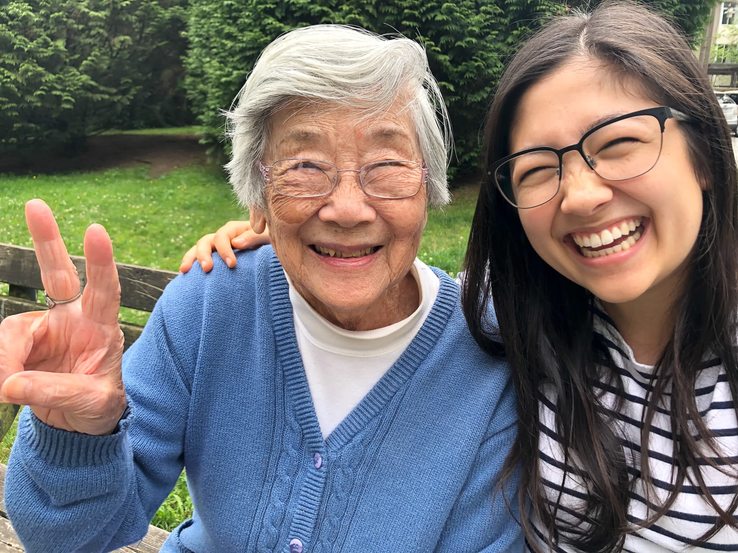 Elderly woman laughing joyfully with a family member outdoors — vibrant and autonomous